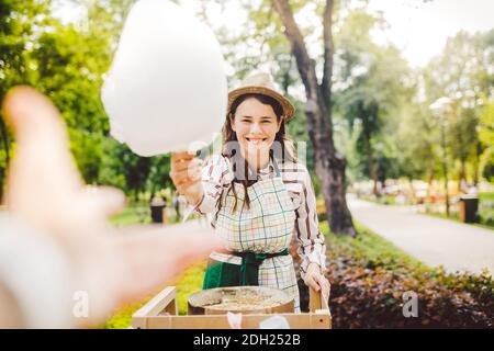 Foto Thema kleine Unternehmen Kochen Süßigkeiten. Eine junge kaukasische Frau mit einem Schürzenhändler im Hut macht der Besitzer des Outlet Stockfoto