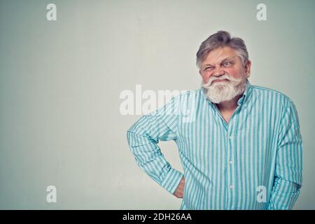 Lustige ältere Mann posiert in einem Fotoshooting. Happy Hipster macht lustige Ausdrücke. Konzept über Menschen und Lifestyle. Stockfoto