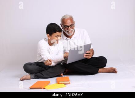 Indischer Großvater unterrichtet Enkel zu Hause Schule oder Unterricht. Stockfoto