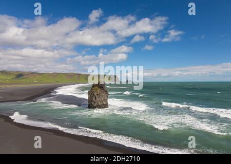 Arnardrangur / Adlerfelsen, Basaltmeer-Stack am Schwarzen Sandstrand Reynisfjara bei Vík í Mýrdal im Sommer, Island Stockfoto