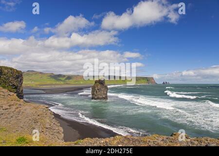 Arnardrangur / Adlerfelsen, Basaltmeer-Stack am Schwarzen Sandstrand Reynisfjara bei Vík í Mýrdal im Sommer, Island Stockfoto