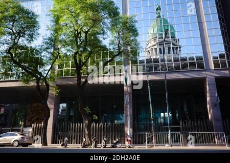 Buenos Aires, Argentinien - Januar, 2020: Kuppel des Nationalkongresses von Argentinien Gebäude in der nächsten Glas Bürogebäude reflektiert. Stockfoto