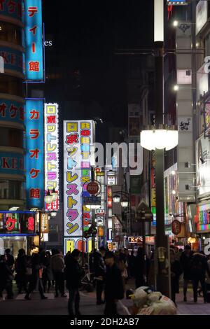 Menschenmassen genießen das Nachtleben unter den Neonlichtern des Tokyo Rotlichtviertels im Shinjuku Kabukicho Bezirk. Stockfoto