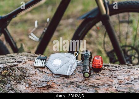 Atemschutzmaske mit Filter PM 2.5. Thema Covid 19. Smog, verschmutzte giftige Luft. Top Biker Zubehör auf Hintergrund Gras im Wald. Stockfoto