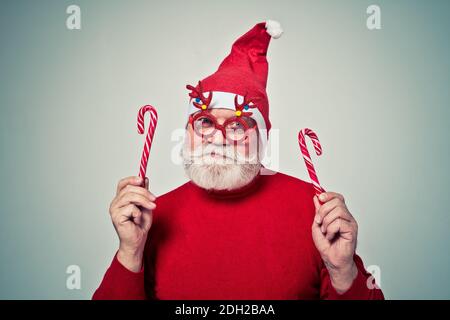 Lustige ältere Mann posiert als weihnachtsmann in einem Fotoshooting. Happy Hipster macht lustige Ausdrücke. Konzept über Menschen und weihnachten Stockfoto