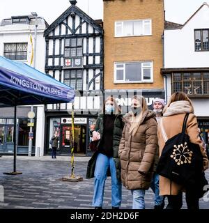 Kingston London, Dezember 09 2020, Junge Frauen mit schützenden Gesichtsmasken, die während der COVID-19 Pandemie zusammen gehen Stockfoto