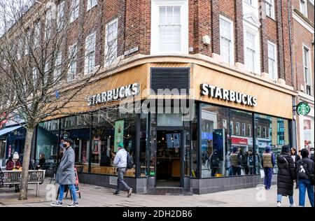 Kingston London, Dezember 09 2020, Starbucks Coffee Shop mit Leuten, die auf dem Bürgersteig oder Bürgersteig vorbeigehen Stockfoto