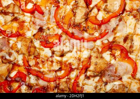 Textur Pizza mit Speck und Huhn Teriyaki serviert auf einem Holzteller, Zutaten Signature Sauce, Mozzarella Käse, Teriyaki Huhn, Speck, Paprika, Teriyaki Sauce. Nahaufnahme. Stockfoto