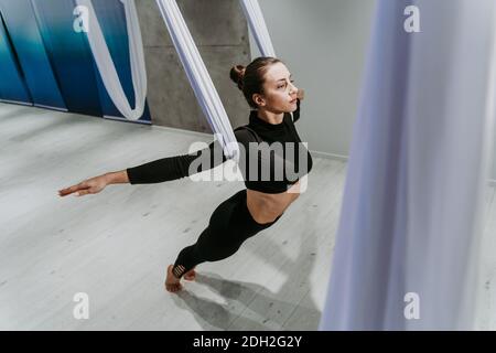 Schöne Mädchen Training in der Turnhalle. Russische klassische Tänzerin macht Stretching und Yoga-Posen Stockfoto