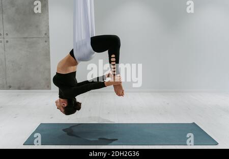 Schöne Mädchen Training in der Turnhalle. Russische klassische Tänzerin macht Stretching und Yoga-Posen Stockfoto