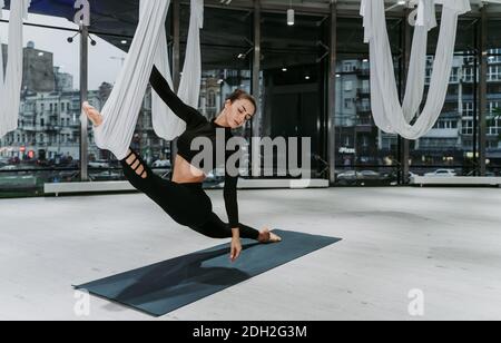 Schöne Mädchen Training in der Turnhalle. Russische klassische Tänzerin macht Stretching und Yoga-Posen Stockfoto