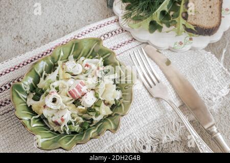 Salat aus Gemüse, grünen Zwiebeln und Krabbenstäbchen Stockfoto