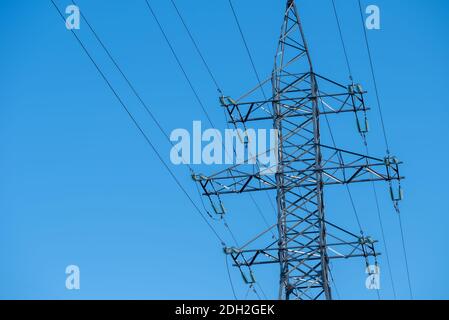 Die Stromleitung ragt gegen den blauen Himmel Stockfoto