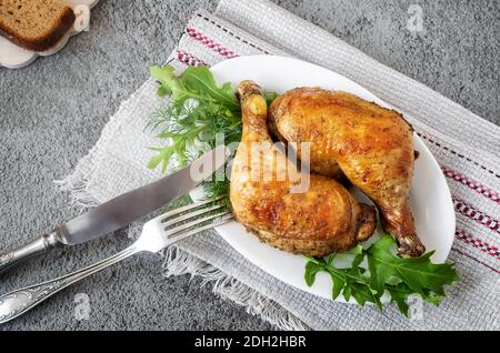 Gebackenes Hähnchenschlagstock auf einem Teller mit Kräutern. Stockfoto