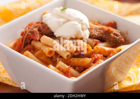 Ricotta-Käse gekrönt Rigatoni mit Shortrib und Erbstück Tomatenragout Soße Stockfoto