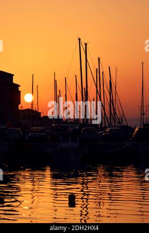 Segel- und Motoryacht bei Sonnenuntergang am Pier. Stockfoto