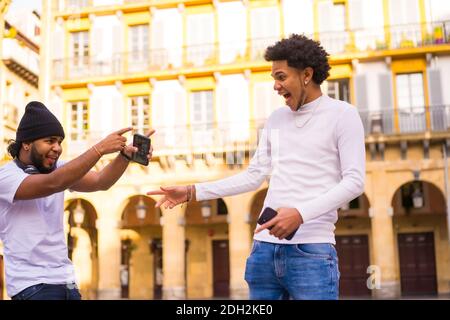 Eine flache Fokus Aufnahme von lateinischen Freunden mit Smartphones mit Spaß im Freien Stockfoto