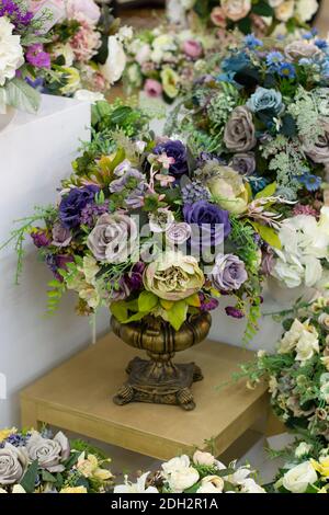 Dekorative Bouquet von künstlichen Rosen, blau weiß lila Stoff Blumen in einer Metallvase, vertikale Fotografie Stockfoto
