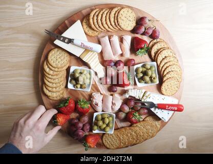 Food Story, Charcuterie-Rad appetitlich, Hand in Frame Stockfoto