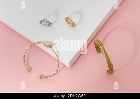 Flaches Lay von goldenen Knoten Form und geflochwerden Form Armbänder Und Klingeln Stockfoto