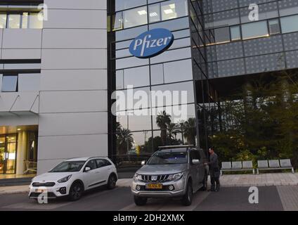 Herzliya, Israel. Dezember 2020. Unter dem Pfizer-Logo steht am Mittwoch, den 9. Dezember 2020, ein Mann vor der Zentrale von Pfizer Pharmaceuticals Israel in Herzliya, Israel. Israel hat heute aus Brüssel seine erste Charge von Pfizer-Coronavirus-Impfstoffen erhalten und wird am 20. Dezember mit der Massenimpfung beginnen, um die COVID-19-Pandemie zu kontrollieren. Foto von Debbie Hill/UPI Kredit: UPI/Alamy Live Nachrichten Stockfoto