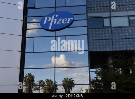 Herzliya, Israel. Dezember 2020. Palmen und Wolken spiegeln sich unter dem Pfizer-Logo am Mittwoch, den 9. Dezember 2020, außerhalb des Hauptsitzes von Pfizer Pharmaceuticals Israel in Herzliya, Israel. Israel hat heute aus Brüssel seine erste Charge von Pfizer-Coronavirus-Impfstoffen erhalten und wird am 20. Dezember mit der Massenimpfung beginnen, um die COVID-19-Pandemie zu kontrollieren. Foto von Debbie Hill/UPI Kredit: UPI/Alamy Live Nachrichten Stockfoto