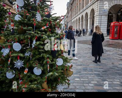 Weihnachtsschmuck in London Covent Garden mit wenigen Besuchern. Covid-19 Lockdown und Covid Tiers haben die Hotellerie ernsthaft beeinträchtigt. Stockfoto