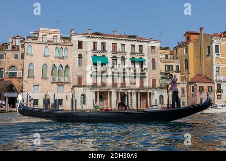 Venedig, Italien - Juli 2, 2018: Closeup Fotografie der Gondel mit Menschen und Gondoliere, im Hintergrund der historischen Gebäude des Grand Canal (Kann Stockfoto