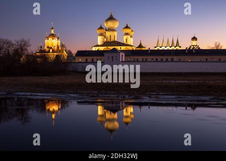 Das Tichwiner Himmelfahrtskloster mit abendlicher Beleuchtung spiegelt sich im Wasser des Flusses Tichwinka, einer wunderschönen Landschaft. Tichwin, Leningrad, reg Stockfoto