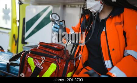 Weibliche Sanitäter packt Sphygmomanometer sitzen in einem Notfall-Fahrzeug Stockfoto