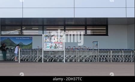 Wien, Österreich - 10. Juli 2015: Außenansicht des berühmten großen deutschen Discounter Lidl mit Leuten, die darauf warten, einen Einkaufswagen zu nehmen, um zu fahren Stockfoto