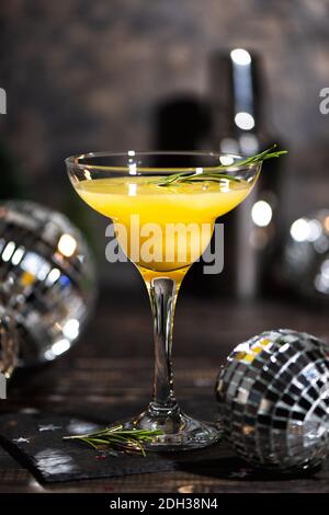 Mimosa Coctail mit Orangensaft und Champagner in den trendigen Farben grau und leuchtendem Gelb der 2021. Neujahrs- oder Geburtstagsparty mit Spiegelscheibe Stockfoto