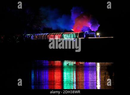 Quorn, Leicestershire, Großbritannien. Dezember 2020. Ein beleuchteter Dampfzug fährt während der Great Central Railway Winter Wonderlights Weihnachtsveranstaltung über das swithland Reservoir. Credit Darren Staples/Alamy Live News. Stockfoto