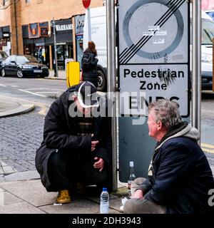 Kingston London, Dezember 09 2020, zwei obdachlose Männer sitzen vor einer ungewissen Zukunft in EINER Rezession sprechen Stockfoto