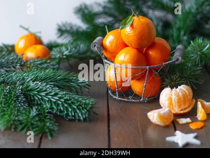 Mandarinen in einem Metallkorb auf einem hölzernen Hintergrund Stockfoto