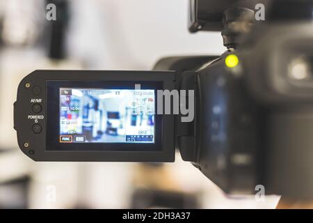 Professionelle Filmproduktion: Männlicher Filmemacher zeichnet mit einer professionellen Filmkamera auf. Nahaufnahme des LCD-Bildschirms der Kamera Stockfoto
