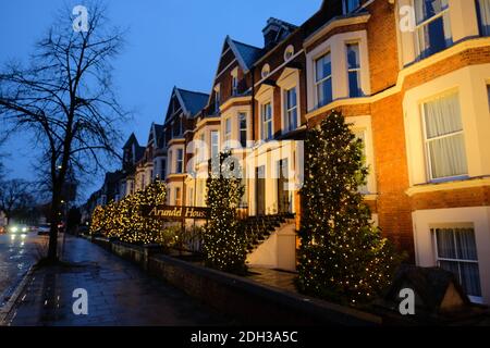 Mehrere festlich geschmückte Häuser in Cambridge City, Menschen setzen weihnachtsbäume vor ihren Häusern, wie die Feiertage nähern sich im dezember Stockfoto