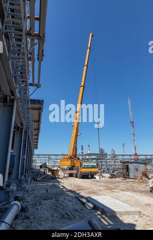 Ein großer gelber LKW-Kran steht bereit für die Arbeit Die Baustelle Stockfoto