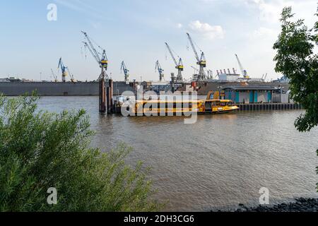 HAMBURG, DEUTSCHLAND - 08. Aug 2020: Blick auf den Hafen von Hamburg mit einer Fähre im Vordergrund Stockfoto