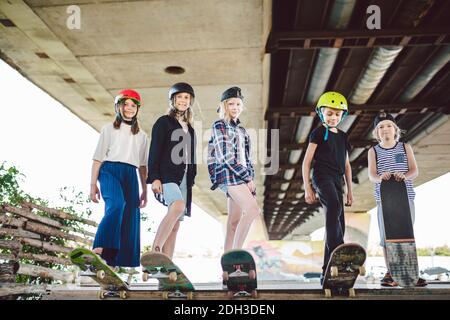 Gruppe von Freunden Kinder auf Skate Rampe. Porträt von selbstbewussten frühen Teenager-Freunden, die im Freiluftstadtskate-Park herumhängen. Leuchtet Stockfoto