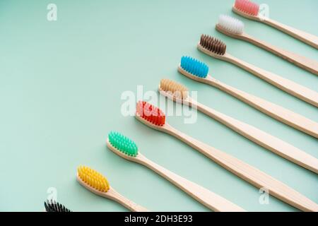 Ein Set umweltfreundlicher antibakterieller Zahnbürsten aus Bambusholz auf hellgrünem Hintergrund. Trends im Bereich Umweltschutz. Stockfoto