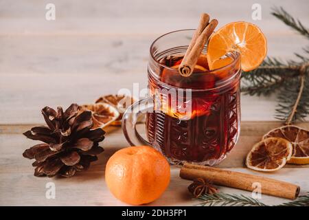 Heißer Glühwein mit Früchten und Gewürzen auf Holzgrund. Winter wärmende Getränk für den Urlaub. Stockfoto