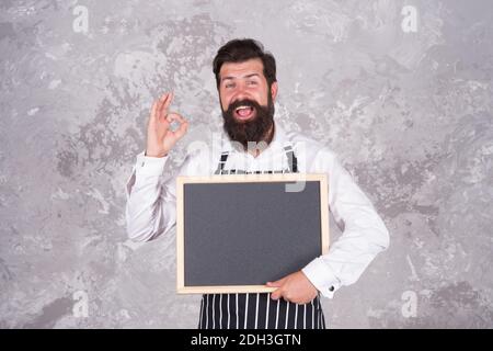 Beste Wahl. werbung und Essen. Kochen nach Rezept. Meisterkurs vom Koch Mann. Bestes Angebot für das Abendessen. Chef Bäcker Menü. Fröhlich gastfreundlich Restaurant Kellner mit Tafel, Kopie Raum. Stockfoto