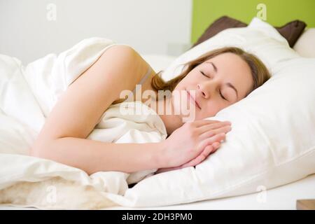 25 -30 jährige Frau schläft im Bett, HERR: Ja Stockfoto