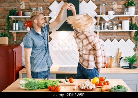 Glücklich junges Paar in der Liebe tanzen in der Küche zu Hause Und Spaß haben Stockfoto