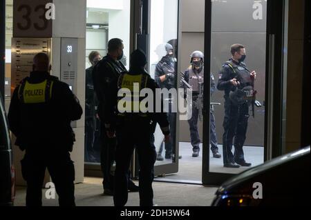 Hamburg, Deutschland. Dezember 2020. Schwer bewaffnete Polizisten stehen in und vor einem Bürogebäude. Wegen eines mutmaßlichen bewaffneten Raubüberfalls in der Hamburger Innenstadt ist die Polizei mit einem großen Kontingent eingezogen. Quelle: Jonas Walzberg/dpa/Alamy Live News Stockfoto