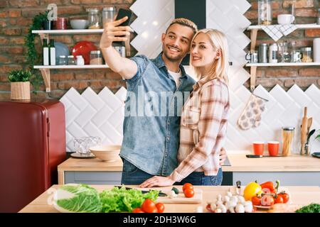 Oung glückliches Paar nehmen Selfie in ihrer Küche Stockfoto