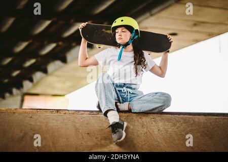 Schulmädchen nach Unterricht im Skateboarding Praxis im Outdoor-Skatepark. Stilvolle und schöne kaukasische Mädchen mit Skateboard o Stockfoto