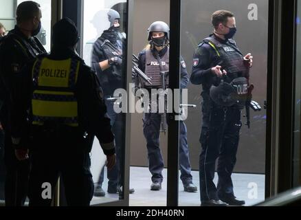 Hamburg, Deutschland. Dezember 2020. Schwer bewaffnete Polizisten stehen in und vor einem Bürogebäude. Wegen eines mutmaßlichen bewaffneten Raubüberfalls in der Hamburger Innenstadt ist die Polizei mit einem großen Kontingent eingezogen. Neu. Quelle: Jonas Walzberg/dpa/Alamy Live News Stockfoto