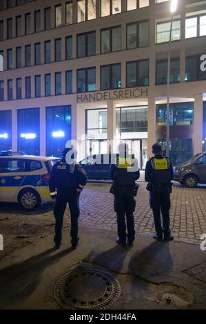 Hamburg, Deutschland. Dezember 2020. Polizisten stehen vor einem Bürogebäude und beobachten den Eingang und die Fassade. Wegen eines mutmaßlichen bewaffneten Raubüberfalls in der Hamburger Innenstadt ist die Polizei mit einem großen Kontingent eingezogen. Quelle: Jonas Walzberg/dpa/Alamy Live News Stockfoto